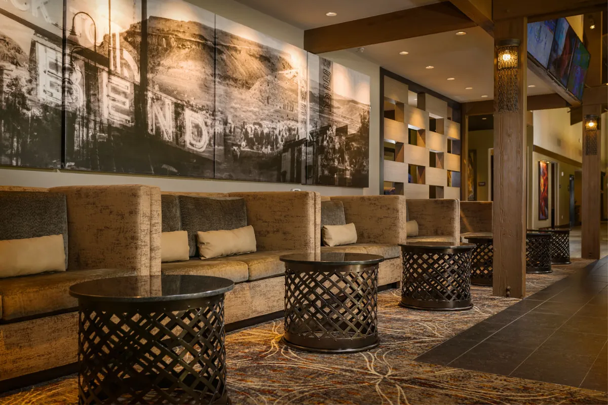 An inviting interior lounge area adorned with large wall art depicting a landscape, stylish seating arrangements, and decorative coffee tables. This communal space encourages relaxation and social interaction, echoing the resort-style ambiance described in the section.